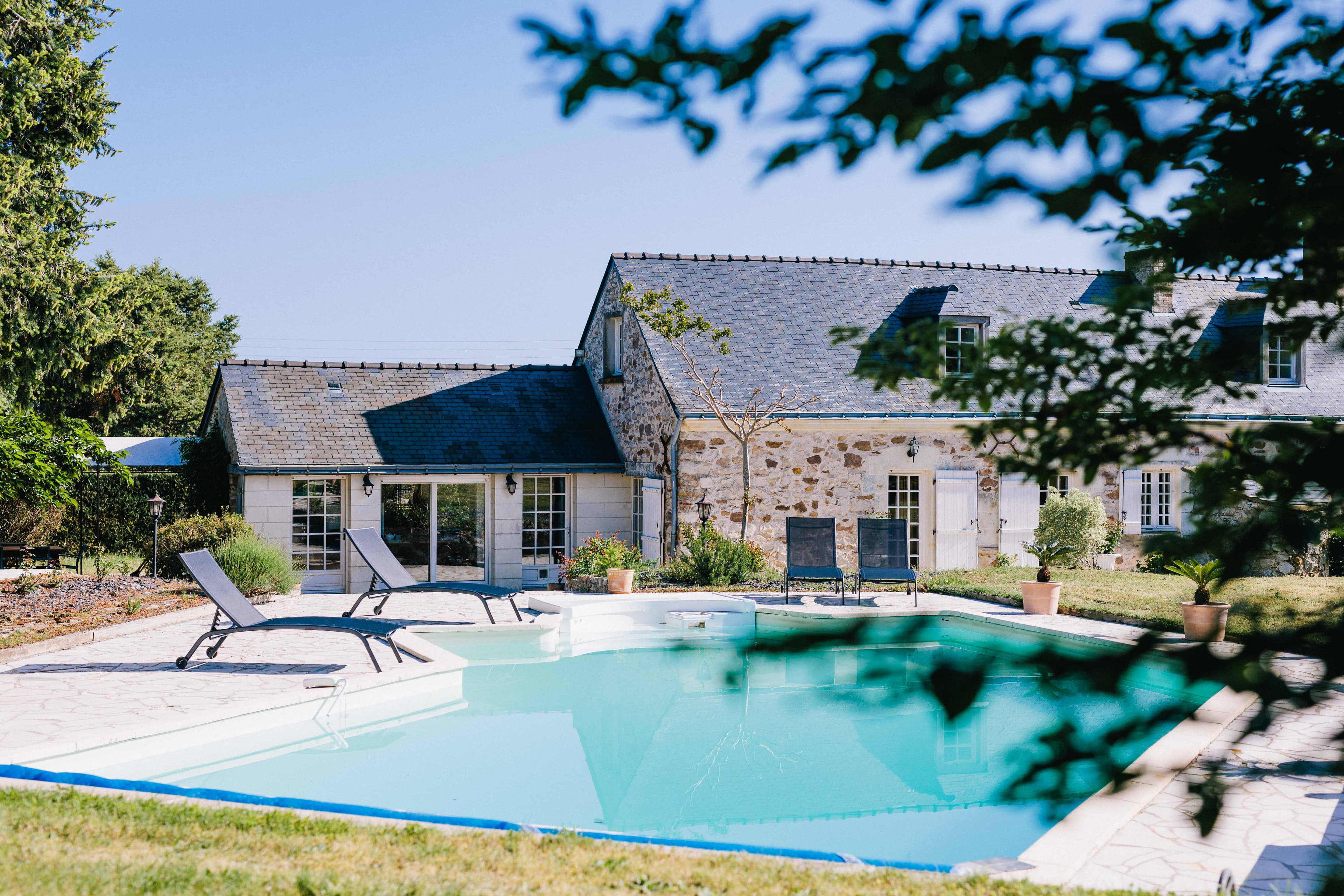 La façade en pierre de La Boire Bavard et sa piscine